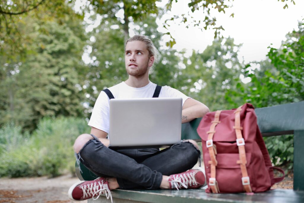 man-sitting-on-bench-with-his-laptop-3981543