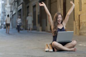 woman-raising-her-hands-up-while-sitting-on-floor-with-3813341